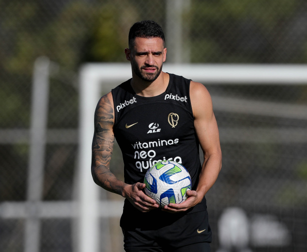 Um jogador de futebol tatuado segurando uma bola.