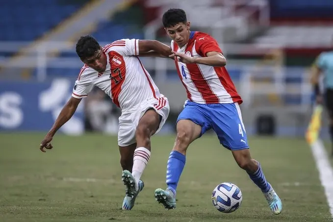 Dois homens do Paraguai e do Peru jogando futebol em um campo.