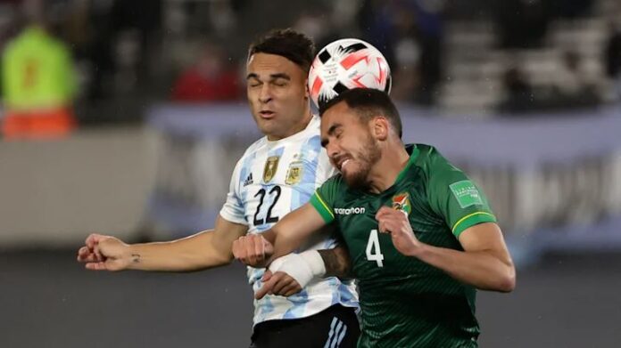 Dois jogadores de futebol da Argentina lutam pela bola.