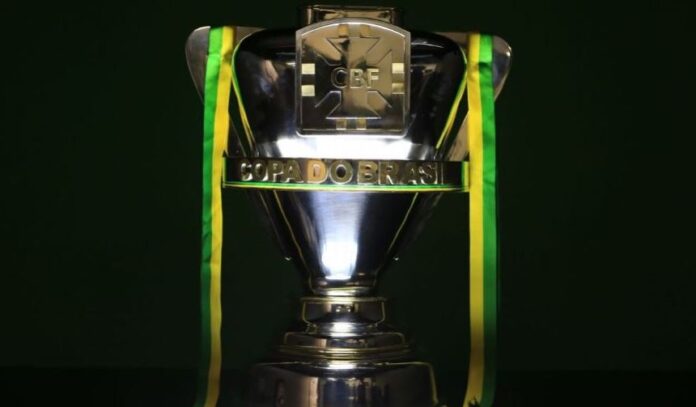 Troféu com inscrição “Copa do Brasil” e logo da CBF, destacado com fitas verdes e amarelas, celebra Flamengo x São Paulo.